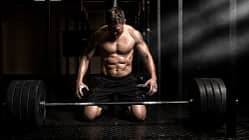 Mann vor schwer beladener Langhantel.