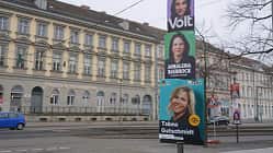 Man sieht eine Straße an der drei Wahlplakate stehen
