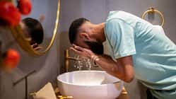 Junger Mann wäscht sich sein Gesicht