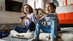 Zwei Kinder sitzen vor einem Fernseher und daddeln