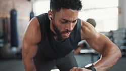 Ein Mann in Sportkleidung schaut auf seine Fitnessuhr