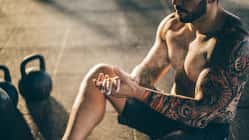 Ein oberkörperfreier Mann mit einem Tattoo am Arm