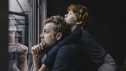 Vater und Sohn gucken aus dem Fenster