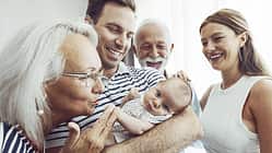 Ein frischgebackener Vater präsentiert den Nachwuchs stolz den Großeltern