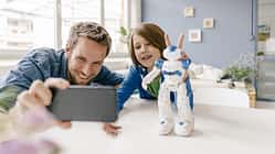 Vater und Sohn spielen mit einem Roboter