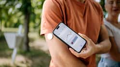 Ein Mann überprüft seinen Blutzucker mit einem Smartphone