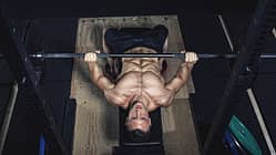 Physical athlete doing barbell bench presses