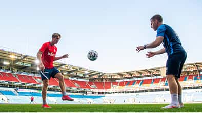 Spieler passt Trainer den Ball aus der Luft mit dem linken Fuß zu.