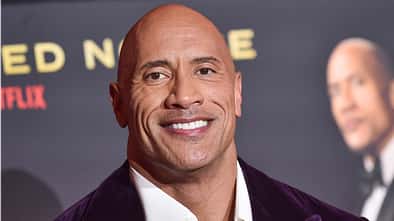 Dwayne Johnsons Gesicht vor dem Hintergrund eines Filmplakats. 