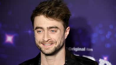 Daniel Radcliffe lächelt auf Premiere in die Kamera