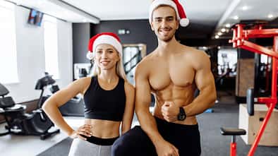 Happy,Sporty,Couple,,In,Santa,Claus,Hats,In,Sportswear,,Show