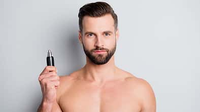 Mann hält einen Trimmer in der Hand Mann hält einen Trimmer in der Hand