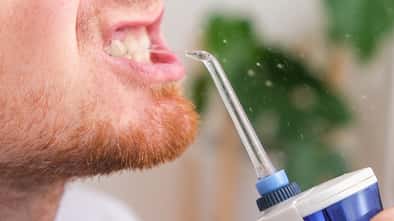 Die Mundstücke eines Water Flossers sollten immer sanft und gezielt ans Zahnfleisch gehalten werden, sonst drohen Entzündungen