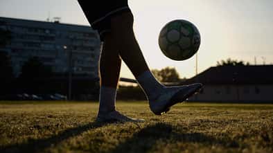 Legs,Of,Young,Man,Kicking,Ball,At,Green,Field.,Male