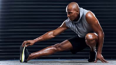 Male,Athlete,,Exercise,And,Stretching,Leg,With,Hand,For,Sports,