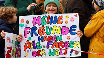 Ein Kind hält auf einer Demo gegen Rechts ein Plakat in die Kamera