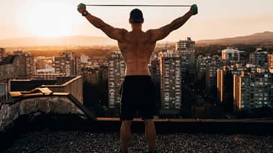 Mann trainiert mit Widerstandsband auf dem Gebäude