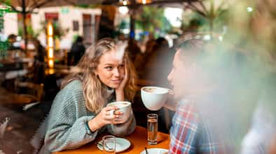 Junge Frau trinkt Kaffee mit einem jungen Mann