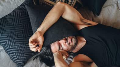 Mann, der sich unwohl fühlt, liegt im Bett