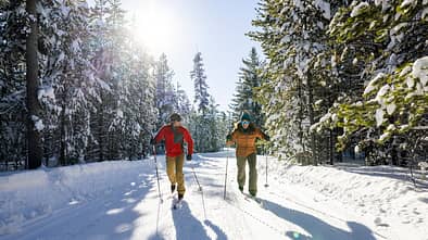 A couple cross country skiing on a beautiful winter day.