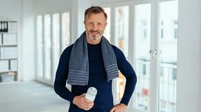 Smiling,Friendly,Athletic,Middle-aged,Man,Standing,Holding,A,Bottle,Of