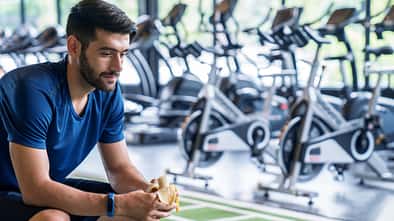 Sports,Man,Eating,Banana,During,Training,In,Gym.