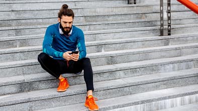 Mit seinem Smartphone nach dem Laufen auf einer Treppe