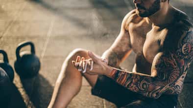 Ein oberkörperfreier Mann mit einem Tattoo am Arm Ein oberkörperfreier Mann mit einem Tattoo am Arm