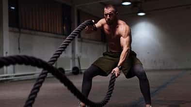 Ein Mann trainiert mit Battle Ropes