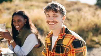 Portrait of happy young man with mustache at dinner party during social gathering