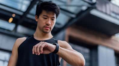 Ein Mann schaut beim Training auf seine Fitnessuhr