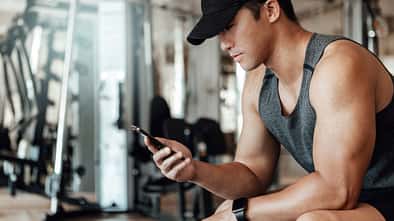 Ein Mann schaut beim Training auf sein Smartphone