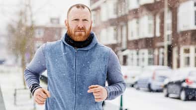 Ein Mann joggt mit einem Pulli im Winter