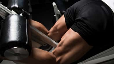 Männliche Beine am Beinstrecker 