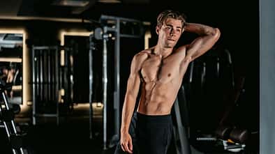 Young Man Flexing Muscles At The Gym