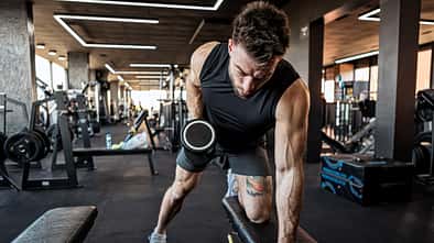 activity Fit Man Exercising with Dumbbells at Gym