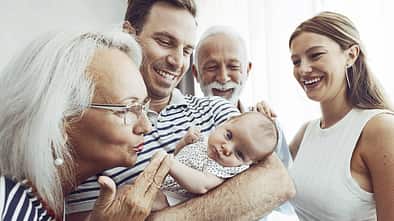 Ein frischgebackener Vater präsentiert den Nachwuchs stolz den Großeltern Ein frischgebackener Vater präsentiert den Nachwuchs stolz den Großeltern