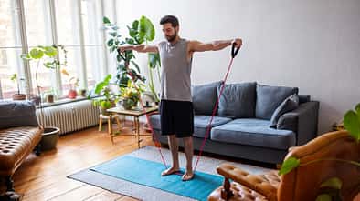 Man watching online videos and doing exercise at home