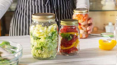 Frisches Gemüse in Einmachgläsern auf der Küchenzeile