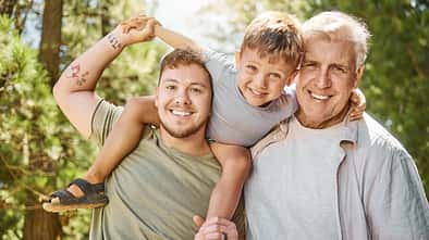 Sohn, Vater und Großvater lächeln in die Kamera