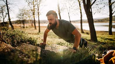 Ein Mann macht draußen erhöhte Liegestütze