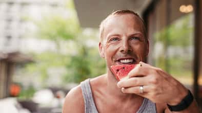 Ein Mann beißt glücklich in eine Wassermelone