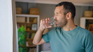Ein Mann trinkt ein Glas Wasser