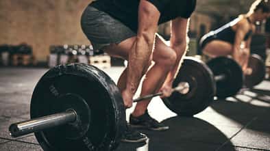 Nahaufnahme eines Mannes, der Deadlifts mit einer Langhantel ausführt