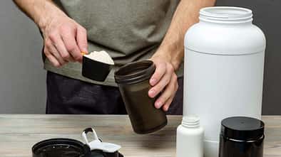The athlete pours protein into a shaker. The concept of sports nutrition.