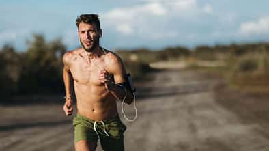 Ein junger Mann joggt oberkörperfrei in der sommerlichen Hitze
