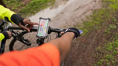 Smartphone ist am Fahrradlenker angebracht und eine Navigationsapp ist geöffnet