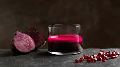 Ein Glas Rote Beete Saft vor dunklem Hintergrund