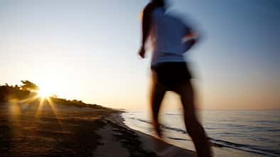 Läufer am Strand beim Sonnenuntergang