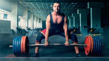 Sumo Deadlift, Kreuzheben Mann beim Sumo Deadlift mit viel Gewicht und breitem Stand